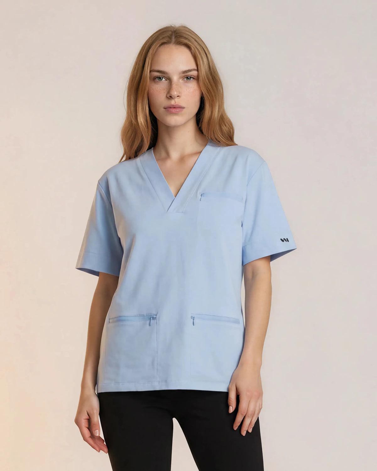 Tunique médicale Sanare bleu ciel col V, portée sur pantalon noir - Le Vêtement Médical