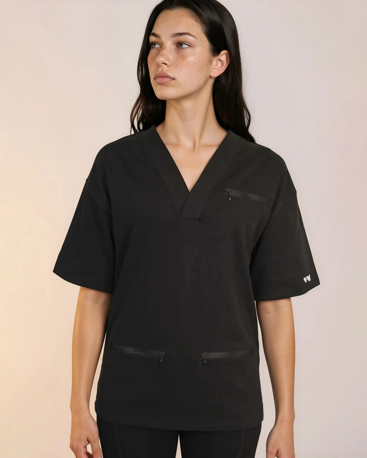 Tunique médicale Sanare noir col V, poches zippées, regard de profil - Le Vêtement Médical